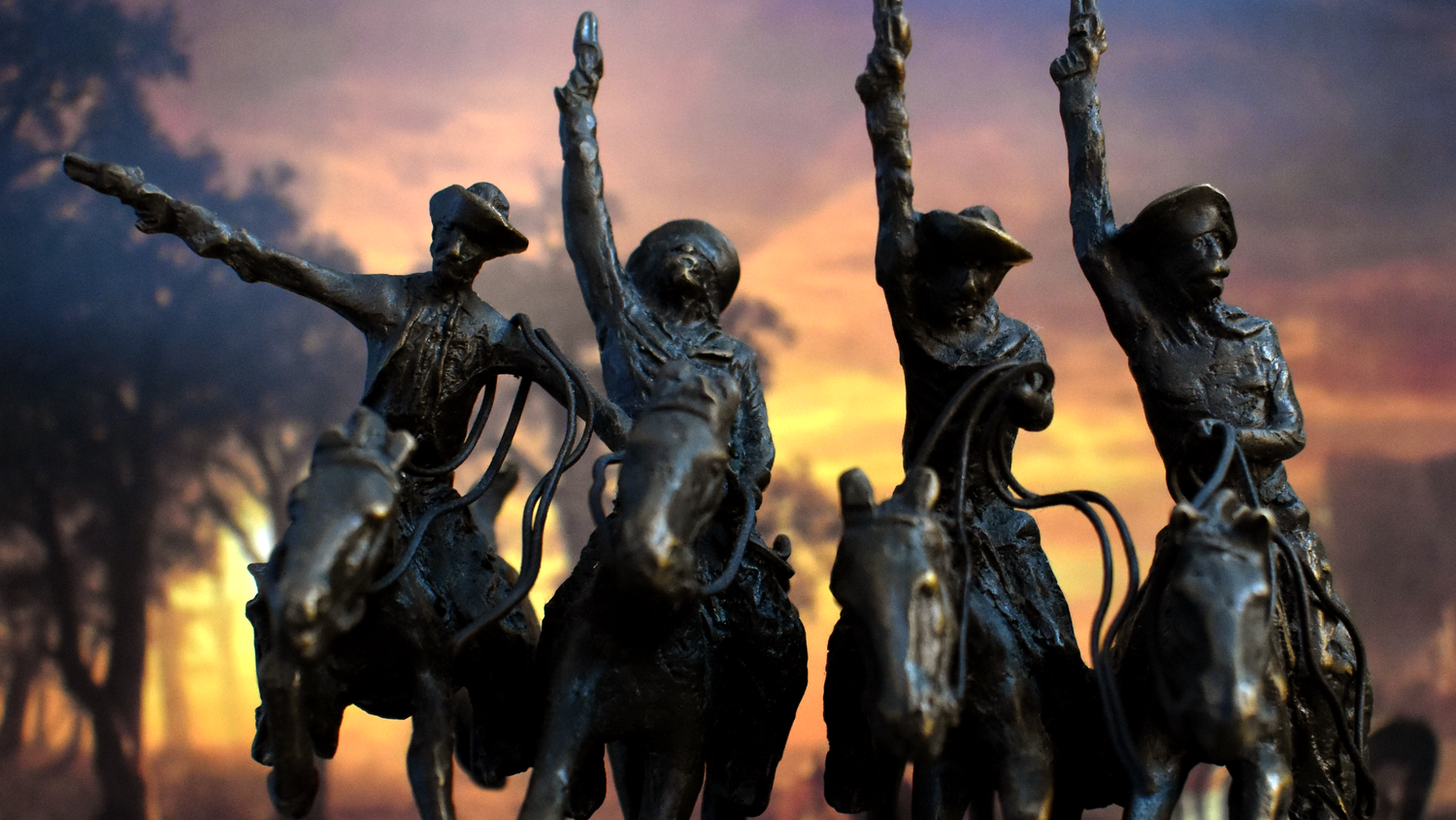 Bronze statue of cowboys riding horses