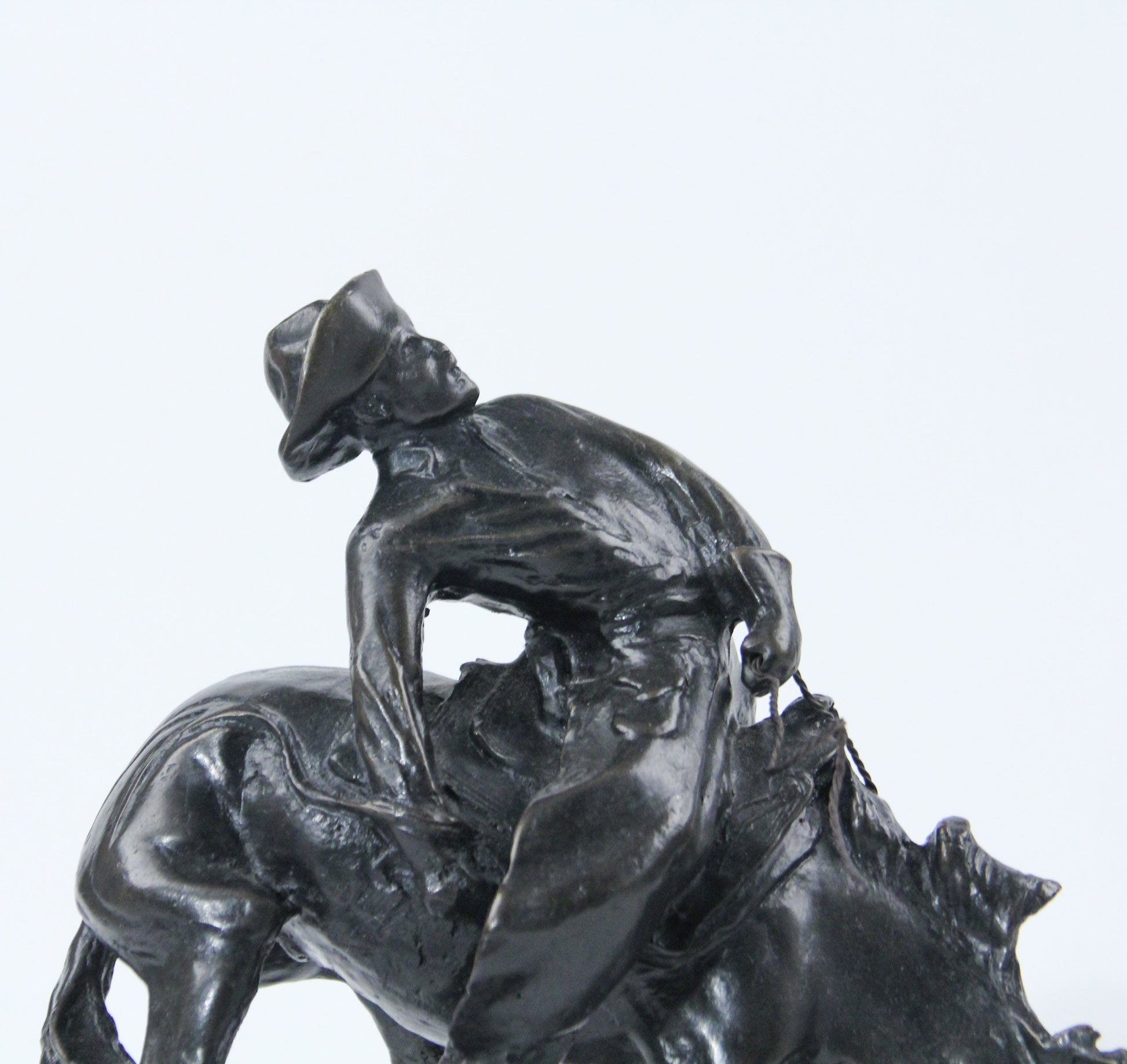 The Outlaw bronze sculpture replica statue by Frederic Remington cowboy on a bucking horse saddle breaking detail face